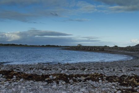 Ein Naturfoto entstanden an der Küste von Irland. Man sieht Steine, das Wasser ist blau und der Himmel auf der Fototour war leicht bewölkt